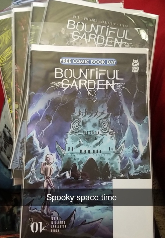 [Image ID: The five issues of Bountiful Garden splayed out on a bed. The first issue is on top and the only one fully visible and is notable for being a Free Comic Book Day copy. The Snapchat captions reads "Spooky space time." End ID]